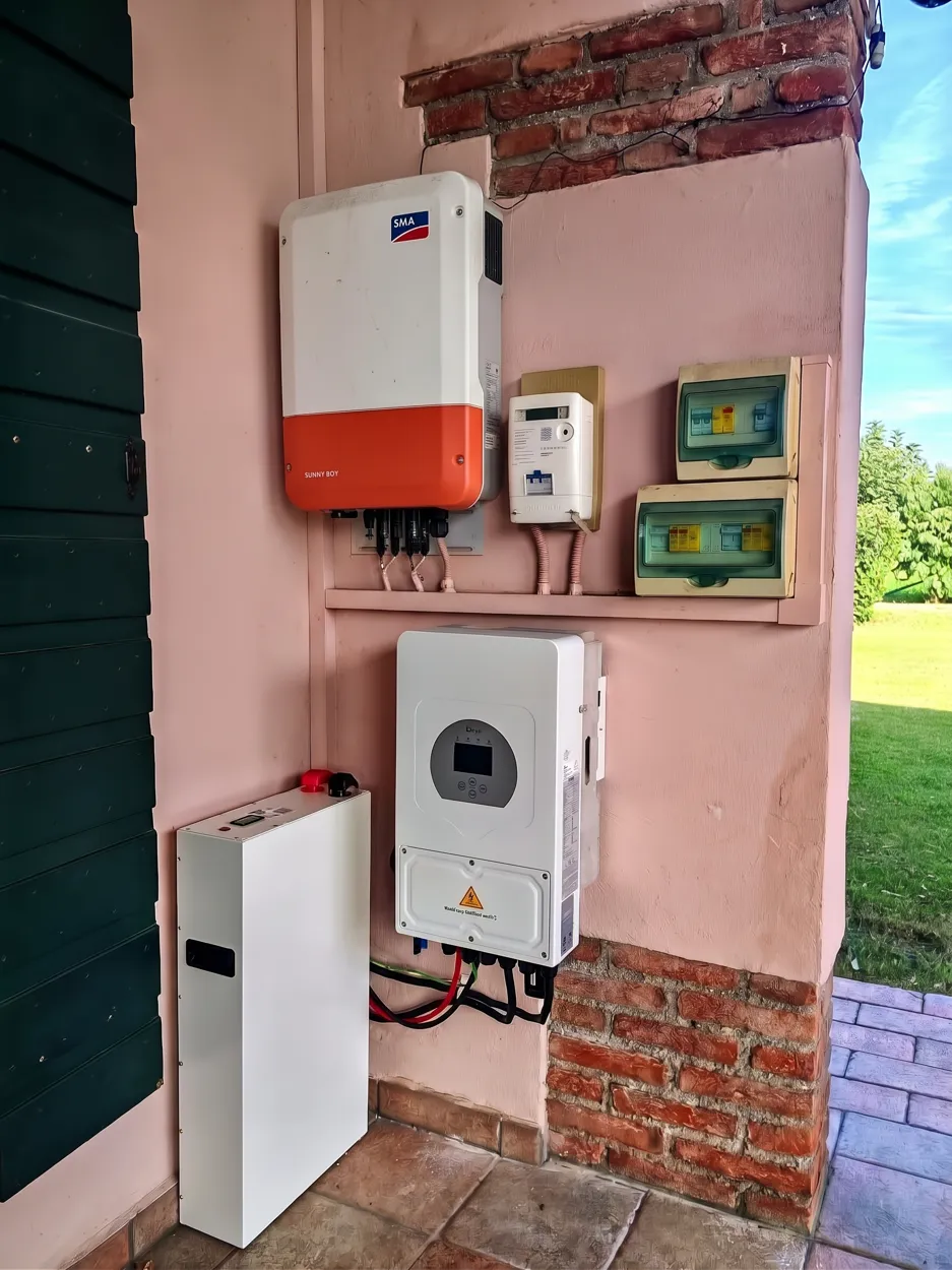 Fotomontaggio illustrativo: inverter SMA Sunny Boy con gateway Deye e modulo batteria IBWT sotto un portico